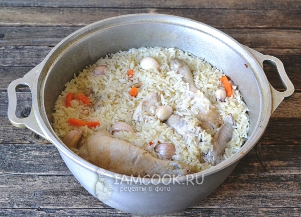 Готовый плов из пропаренного риса с курицей в казане