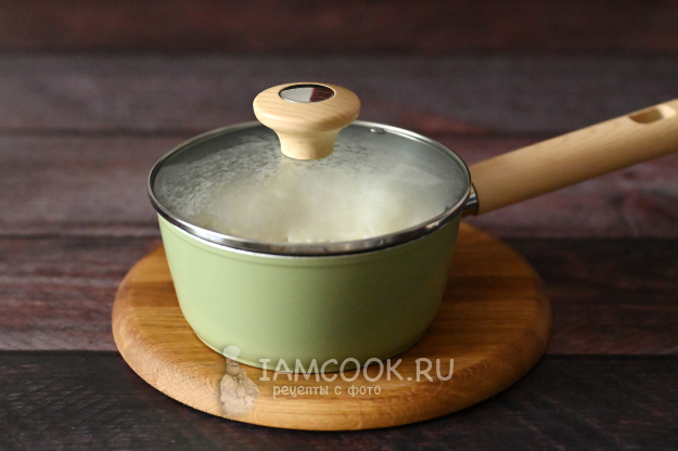 Кокосовая стружка, вмешанная в рисовую кашу, ковш укутан полотенцем