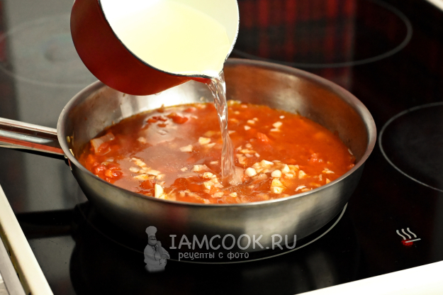 Вливание бульона в сковороду с овощами и томатами