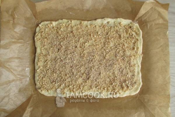 Посыпать тесто ореховой начинкой