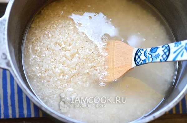 Вымытый рис с водой в казане
