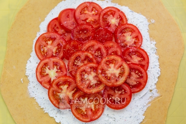 Положить на тесто творог и помидоры