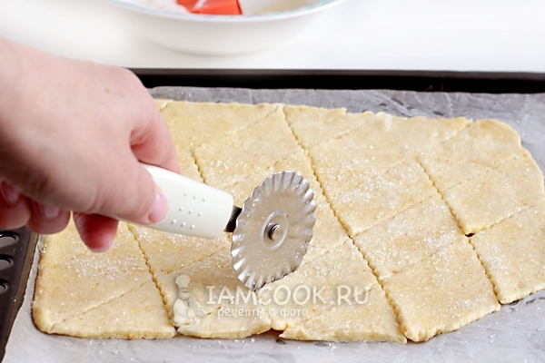 Посыпать тесто сахаром и разрезать на ромбики